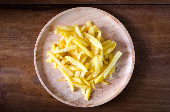 French fries on wood dish on wooden background.