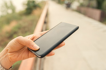 Close up of hands woman using smart phone in the city.