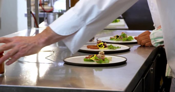 Chef pouring salad dressing over a salad