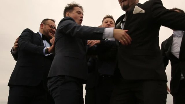 nine men in suits having fun 