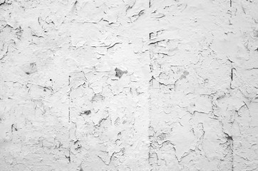 Cracked flaking white paint on old stone wall