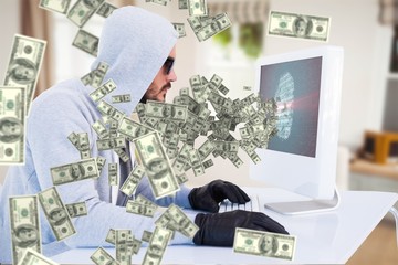Composite image of serious burglar hacking into laptop