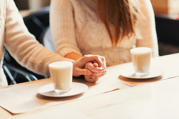 couple holding hands with coffee
