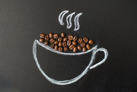 cup drawn with chalk on black board and real coffee beans