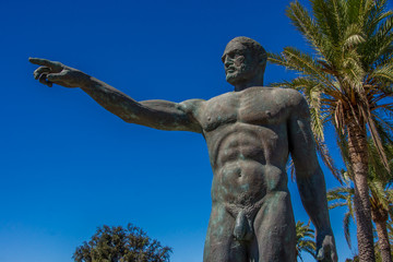 Bronzestatue eines Mannes zeigt in eine Richtung