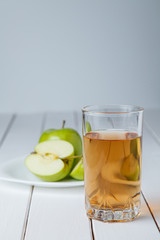 Cut green apples and glass of fresh apple juice
