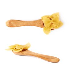 Set of wooden spoon filled with dry farfalle pasta over isolated white background