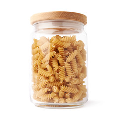 Glass jar filled with dry rotini pasta over isolated white background