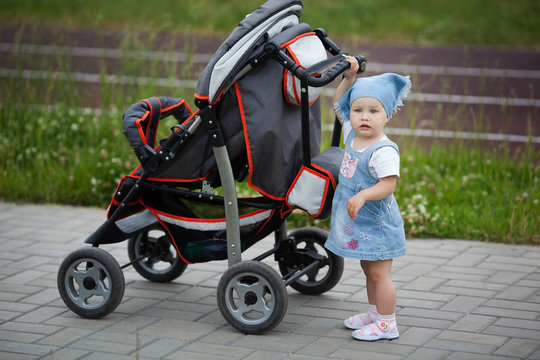 little funny girl with baby carriage