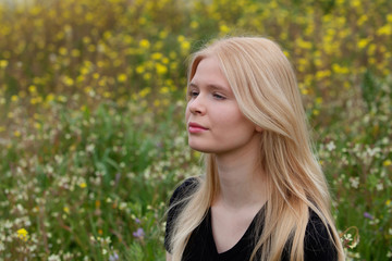 Fototapeta premium Happy blonde girl surrounded by flowers
