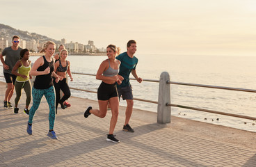 Young runners workout along a seaside promenade © Jacob Lund