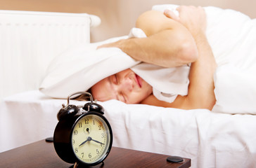 Man trying to sleep, when alarm clock ringing