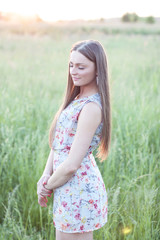 Fototapeta na wymiar Beautiful girl field green meadow in summer park delicate dress, enjoying leisure, fashion style, glamor life, student at a bright sunny day.