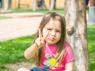 Fototapeta premium little girl outdoors shows gestures