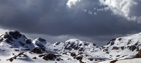 Fototapeta premium Panoramic view on snowy mountains in clouds
