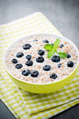 Buckwheat porridge in a bowl with mint leaves and blueberries.