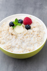 Oatmeal porridge in bowl with berries raspberries and blackberri