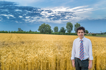 Naklejka na ściany i meble cute caucasian boy in a wheat field