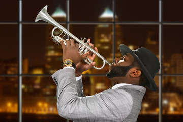 Darkskinned trumpeter in fedora hat. Trumpeter playing in night megalopolis. Music and passion are...