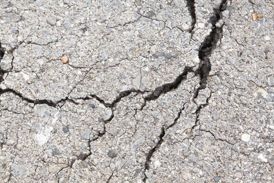 Macro closeup on concrete asphalt cracks on the road.
