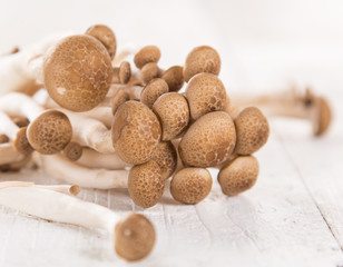 brown beech mushroom on white wooden background.