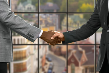 Formally dressed men shaking hands. Officials shake hands at midday. Appreciating the support. Always ready to help.