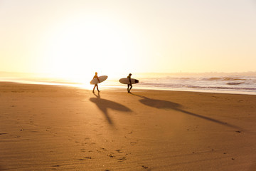 Surfers on the beach - obrazy, fototapety, plakaty