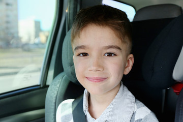 little european boy sitting in safety car seat