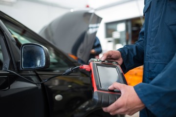 Mechanic using a diagnostic tool at the repair garage