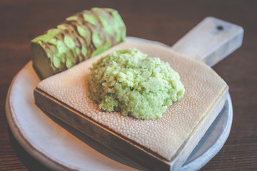 Grind grated fresh wasabi on a plate made of shark skin.