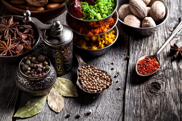 Spices and nuts at wooden table - obrazy, fototapety, plakaty