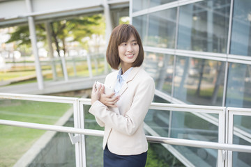 Attractive asian business woman working on tablet computer outsi