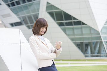 Attractive asian business woman working on tablet computer outsi