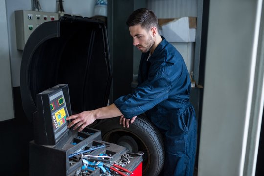 Mechanic prepares a tyre balance machine