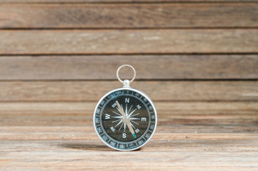 Compass on wooden texture.