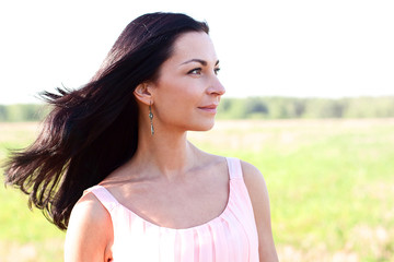 Beautiful woman standing in a field pink dress, fashion style, the concept of portrait outdoor