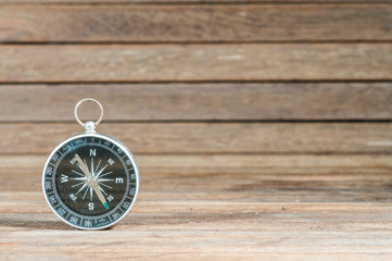 Compass on wooden texture.