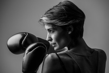 foto b/n di Donna con guantoni di profilo che tiene la guardia 