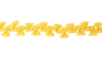 Line made of dry farfalle pasta over isolated white background