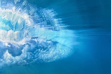 Washable wall murals Water Underwater photo of ocean extreme wave breaking on tropical beach with spray, foam, ripples on water surface and bubbles pattern. Light blue color abstract background of clear sea surf with texture