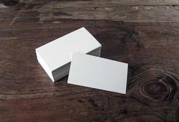 Photo of blank business cards on dark vintage wooden background. For design presentations and portfolios.