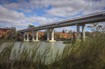 Concrete highway bridge arcoss river cliffs at waterfront