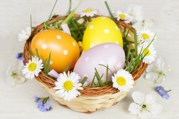Obraz na płótnie Canvas Happy Easter! Easter card.Easter eggs in a basket with grass and spring flowers.A nice and festive decoration.