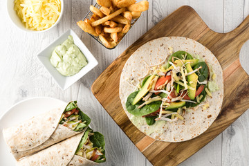 shredded barbecued chicken wraps with carrot, cheese, avocado an