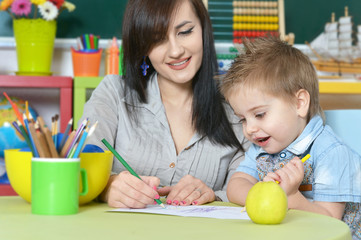 little boy drawing  with mother
