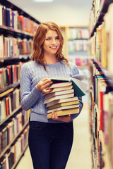 happy student girl or woman with books in library