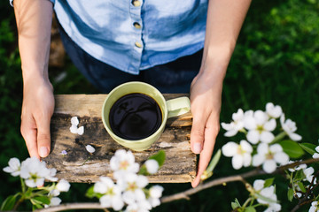 Girl cook freshly ground coffee for a picnic in the spring garden