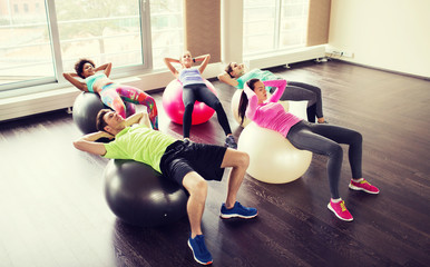 happy people flexing abdominal muscles on fitball