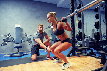 man and woman with bar flexing muscles in gym