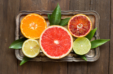 Fresh citrus fruits with leaves on a  wooden table